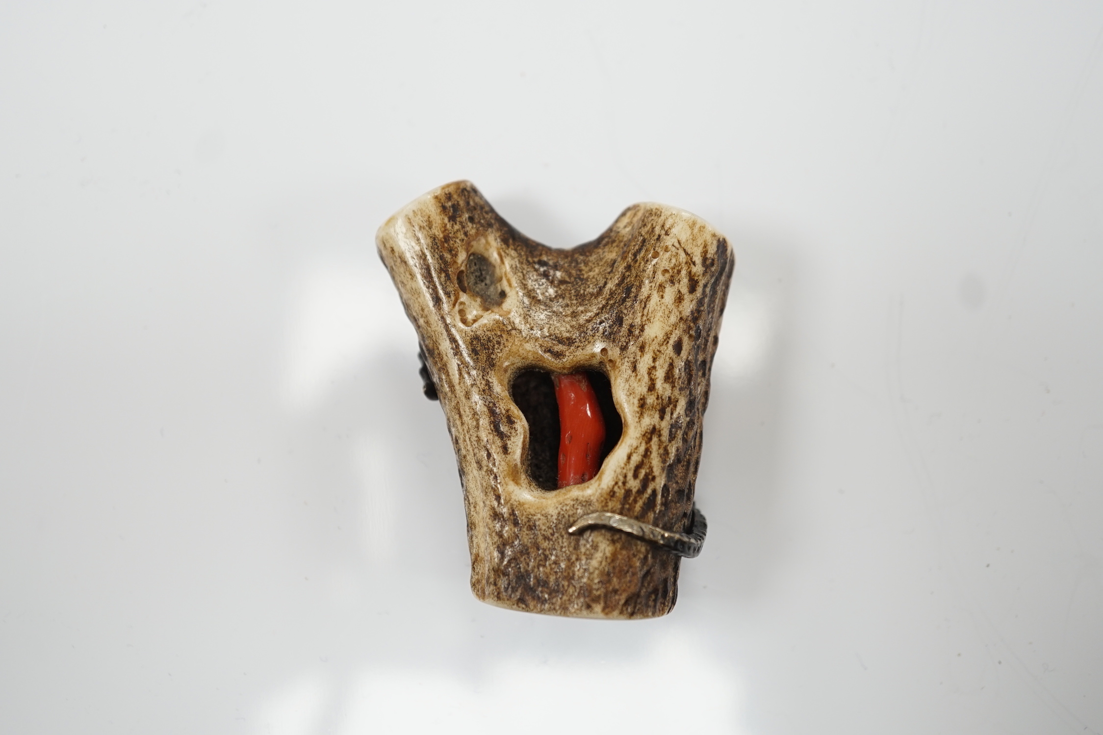 A Japanese coral and mixed metal mounted stag antler netsuke, 19th century, the antler carved in imitation of rocks applied with a white metal seahorse, gilt metal scallop shell, carved bone barnacles, the underside holl